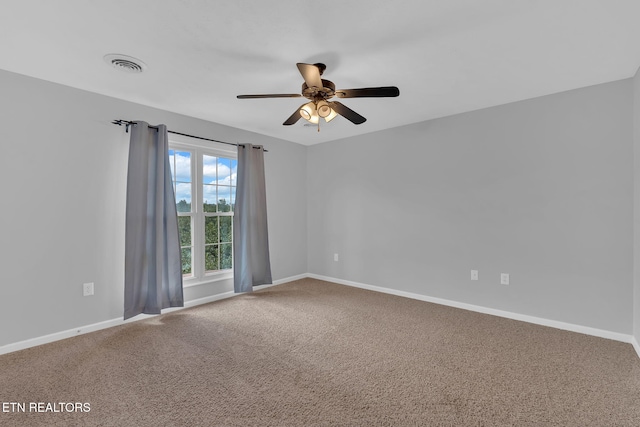 unfurnished room with carpet floors, visible vents, and baseboards