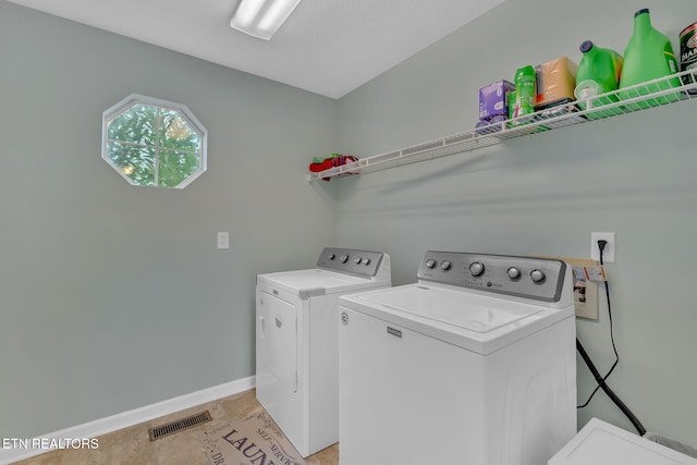 clothes washing area with laundry area, washer and clothes dryer, visible vents, and baseboards