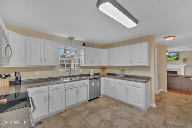 kitchen with stainless steel appliances, white cabinets, and a sink