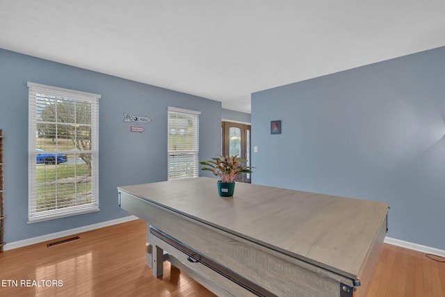 dining room with a wealth of natural light, light wood-style flooring, visible vents, and baseboards