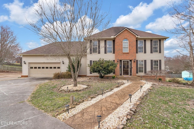 view of front of home with an attached garage, driveway, a shingled roof, and brick siding