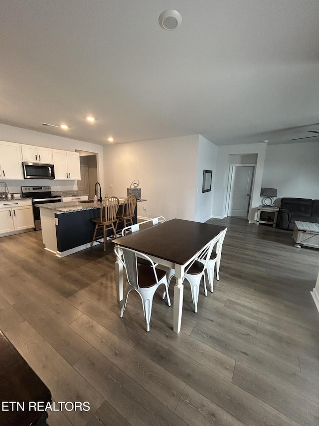 dining room with dark wood finished floors and recessed lighting