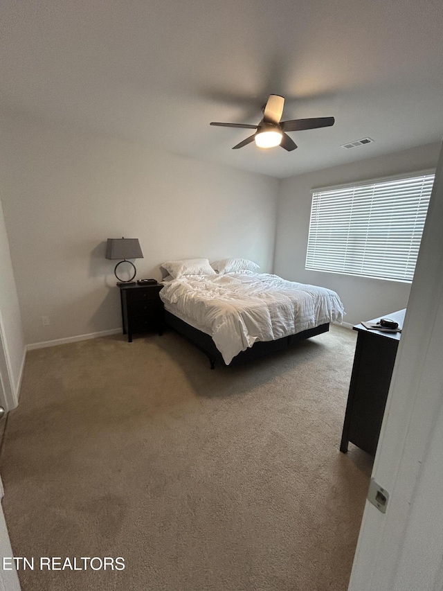 carpeted bedroom with baseboards, visible vents, and a ceiling fan