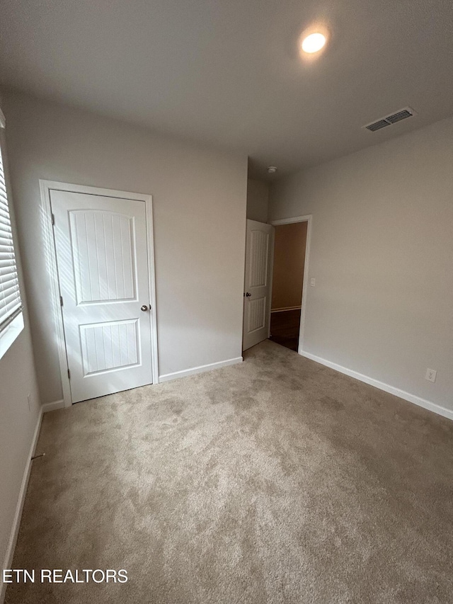 carpeted spare room with baseboards and visible vents