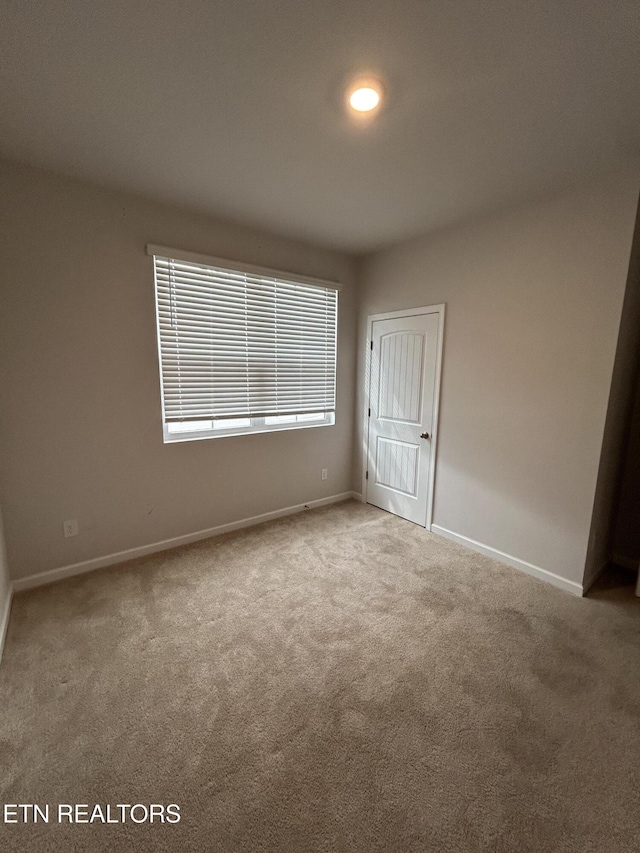 unfurnished room featuring carpet flooring and baseboards