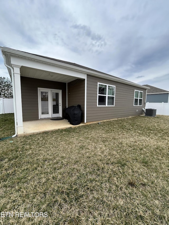 rear view of house with central AC, a lawn, a patio, and fence