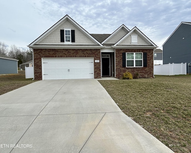 craftsman house with a front yard, brick siding, fence, and driveway