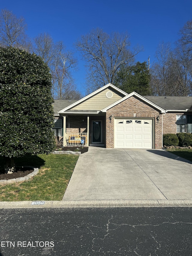 view of front of house featuring brick siding, a porch, concrete driveway, and a garage