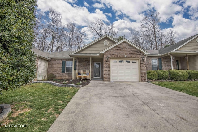 view of front of home featuring brick siding, a porch, a front yard, a garage, and driveway