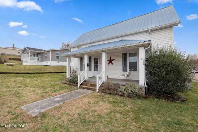 view of front facade featuring covered porch, metal roof, and a front lawn