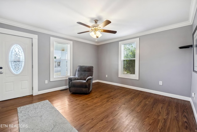 living area with crown molding, baseboards, ceiling fan, and wood finished floors