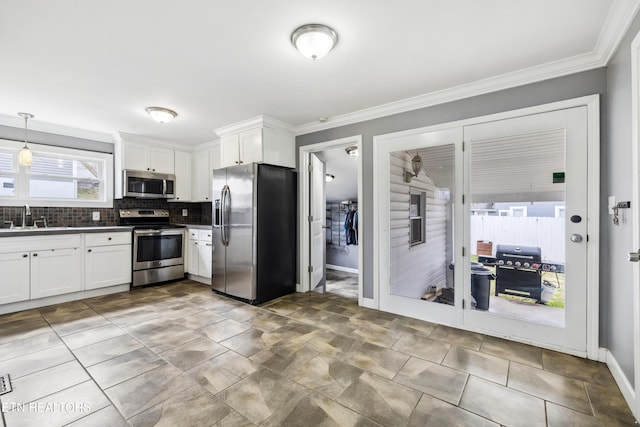 kitchen with stainless steel appliances, dark countertops, tasteful backsplash, white cabinets, and a sink