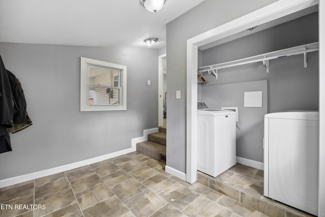 interior space featuring washing machine and dryer, a walk in closet, and baseboards