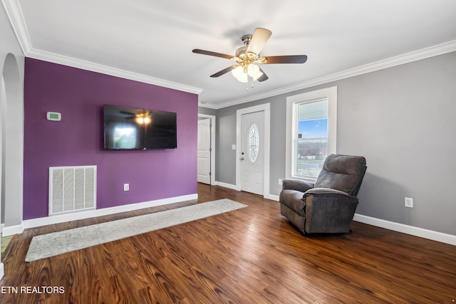 interior space with baseboards, visible vents, arched walkways, wood finished floors, and crown molding