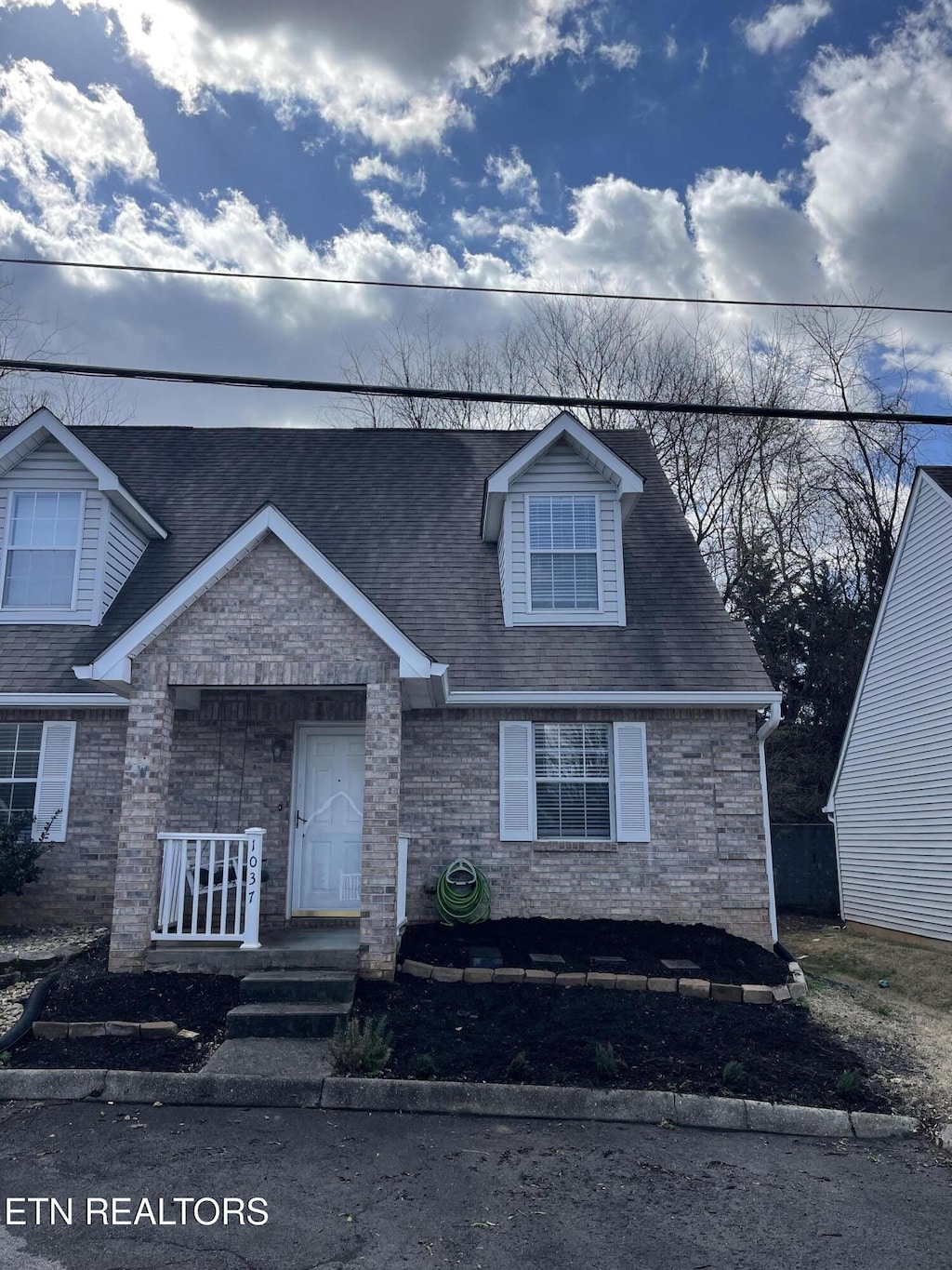 view of front of property with covered porch and brick siding