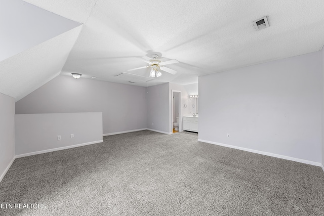 interior space with visible vents, a textured ceiling, lofted ceiling, and a ceiling fan