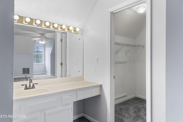 bathroom featuring baseboards, a textured ceiling, vanity, and ceiling fan