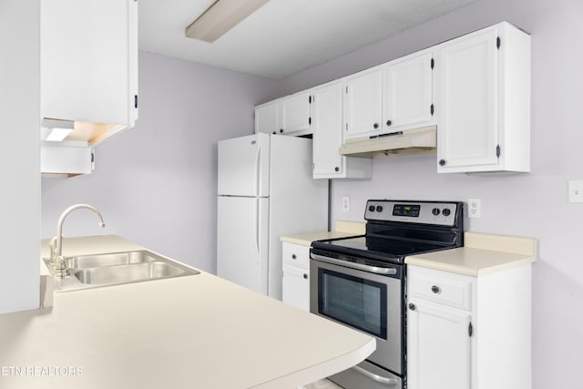 kitchen featuring electric stove, under cabinet range hood, a sink, freestanding refrigerator, and light countertops