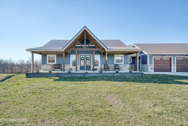 view of front of house featuring a garage, stone siding, and a porch