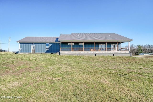 rear view of house featuring metal roof and a lawn