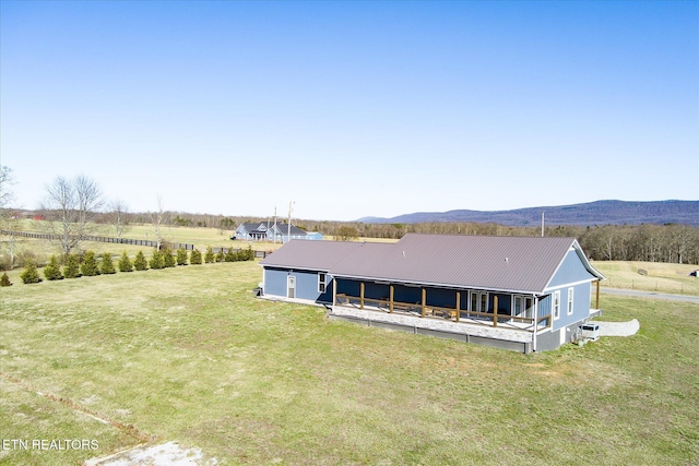 exterior space featuring a front yard, a rural view, metal roof, and a mountain view