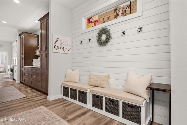 mudroom with wood walls, light wood-type flooring, and recessed lighting