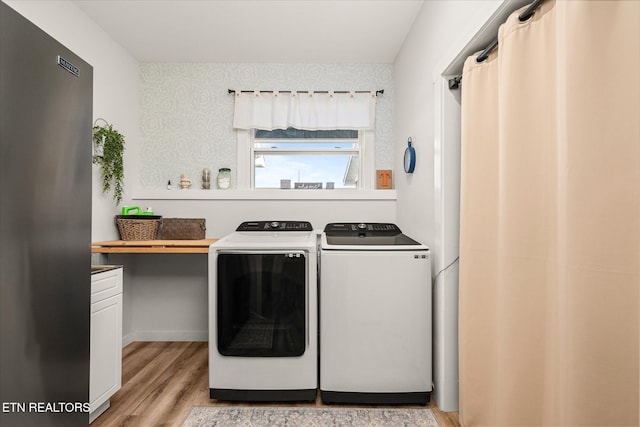 laundry room featuring light wood-type flooring, washing machine and dryer, and laundry area