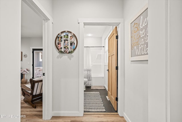 hallway with baseboards and wood finished floors