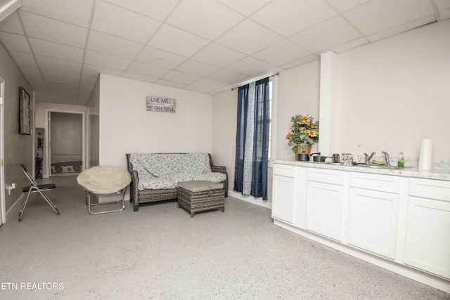 living area featuring a drop ceiling