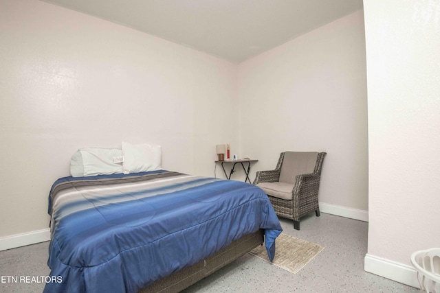 bedroom with speckled floor and baseboards