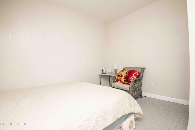 bedroom with concrete floors and baseboards