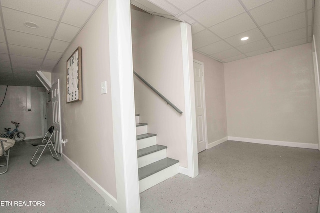 stairway with recessed lighting, a drop ceiling, and baseboards