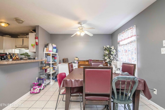 dining room featuring a ceiling fan, baseboards, and light tile patterned floors