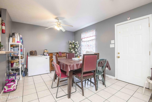 dining room with ceiling fan, baseboards, and light tile patterned floors