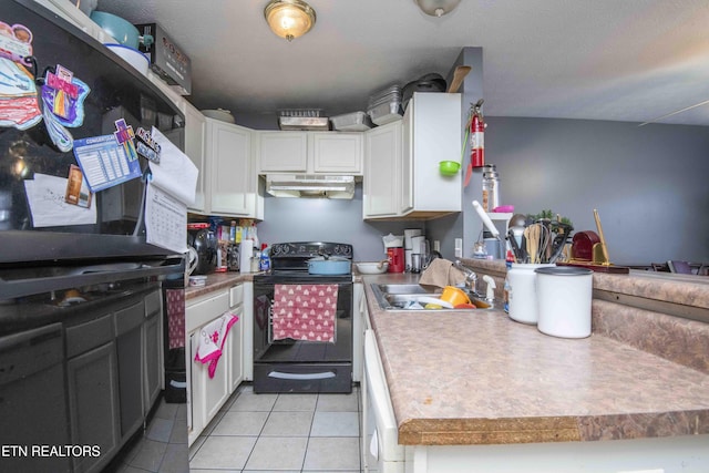 kitchen featuring light tile patterned floors, electric range, white cabinets, under cabinet range hood, and a sink