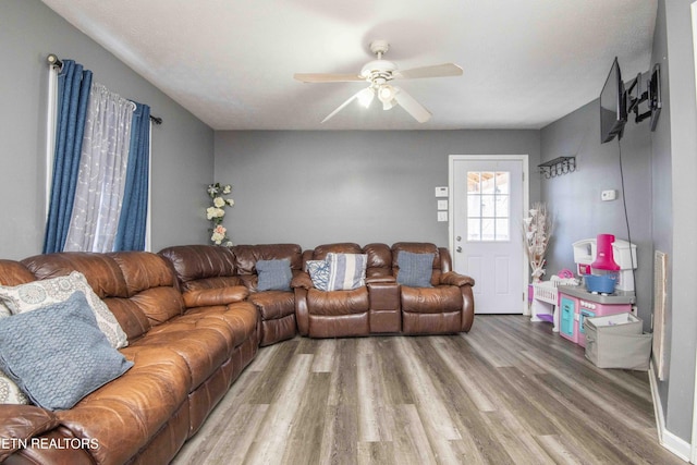 living room featuring wood finished floors and a ceiling fan