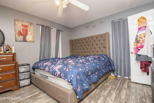 bedroom featuring a textured ceiling, wood finished floors, and a ceiling fan