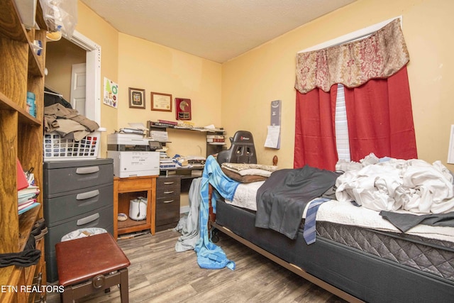 bedroom with light wood-type flooring and a textured ceiling