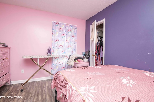 bedroom with a closet, baseboards, and wood finished floors