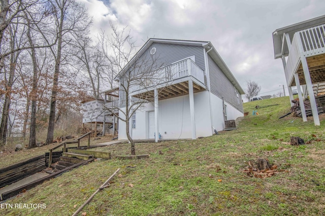 rear view of property featuring a yard, stairway, and a wooden deck