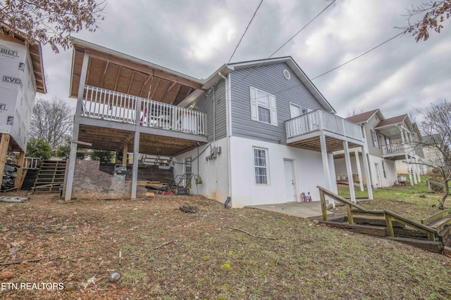 rear view of property featuring a patio and stairway