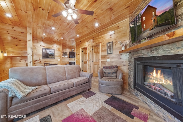 living area with a stone fireplace, recessed lighting, wooden walls, wood finished floors, and wood ceiling