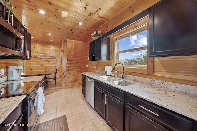 kitchen with stainless steel appliances, wooden ceiling, a sink, and wooden walls