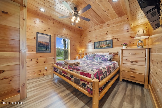 bedroom featuring wooden ceiling, a ceiling fan, wood finished floors, and wood walls