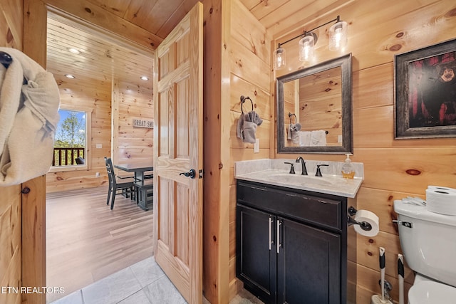 bathroom featuring wooden ceiling, wood walls, toilet, and tile patterned floors