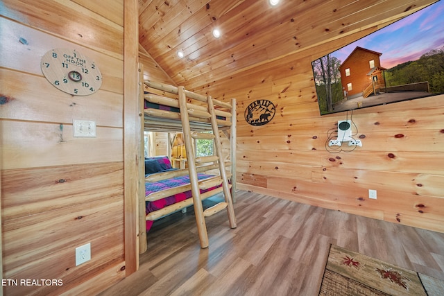 bedroom featuring wood ceiling, vaulted ceiling, wooden walls, and wood finished floors