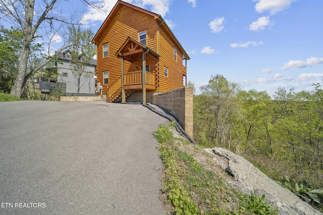 view of front of home with driveway and log exterior