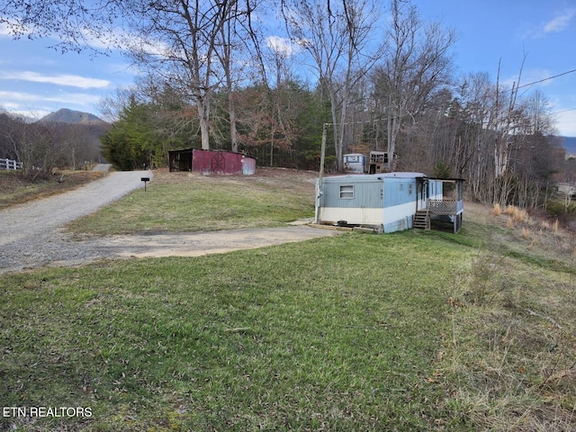 view of yard featuring driveway and a mountain view