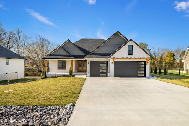 view of front of property featuring a garage, a front yard, driveway, and a porch