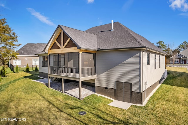 rear view of property featuring crawl space, a shingled roof, and a yard